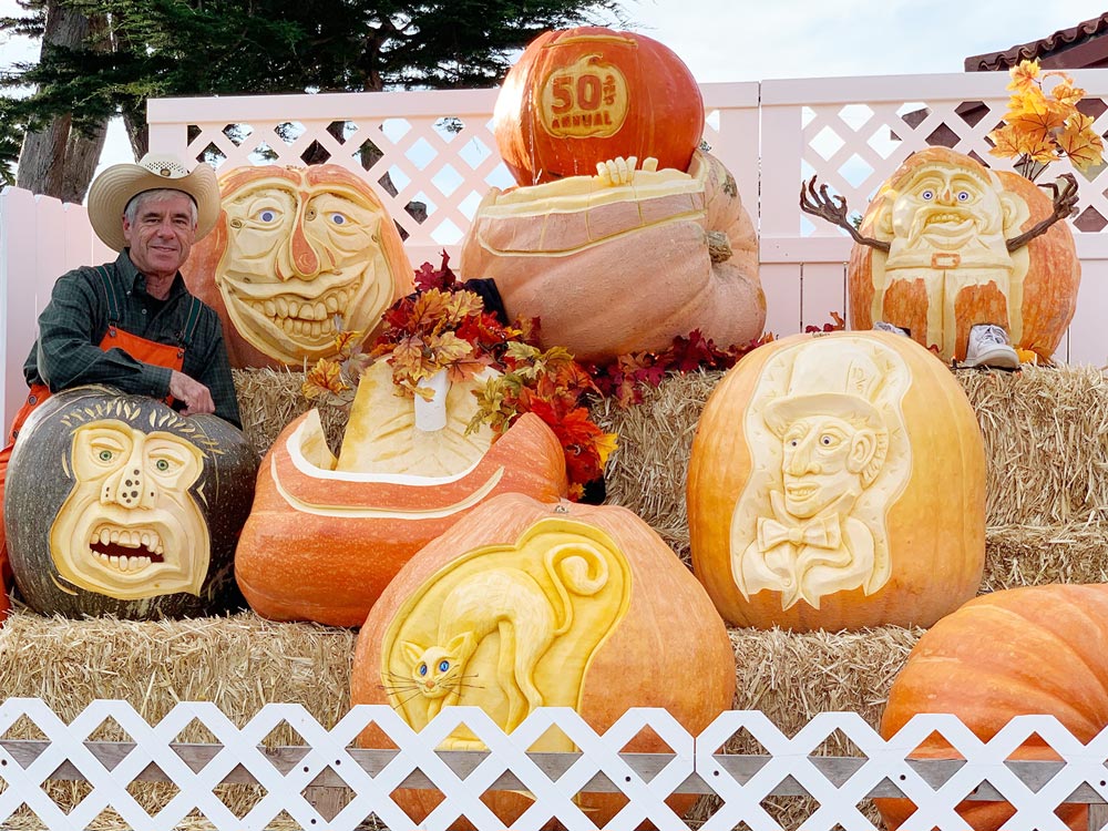 Farmer Mike poses with his 50th anniversary Pumpkin Festival 3-tier carved pumpkin water feature