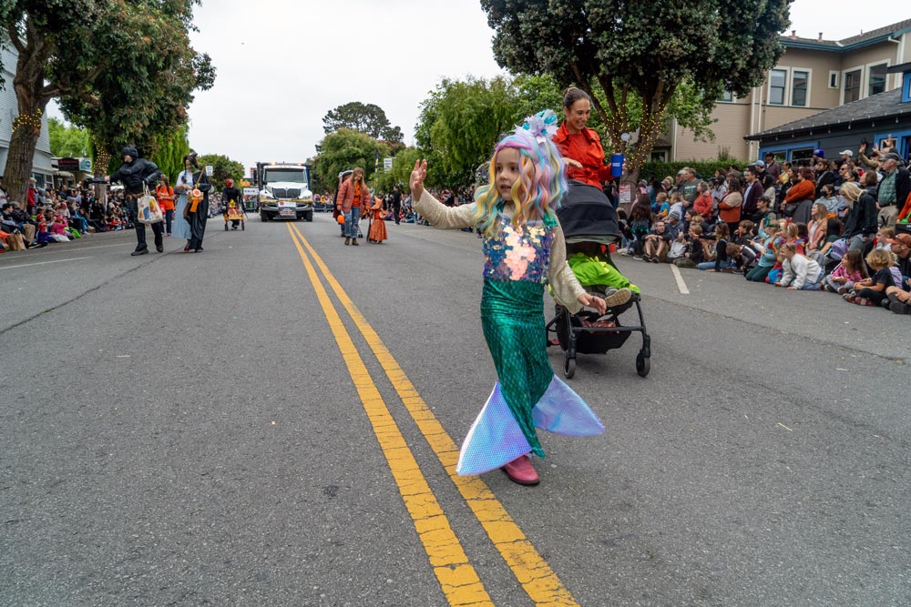 child mermaid in costume contest walks in parade
